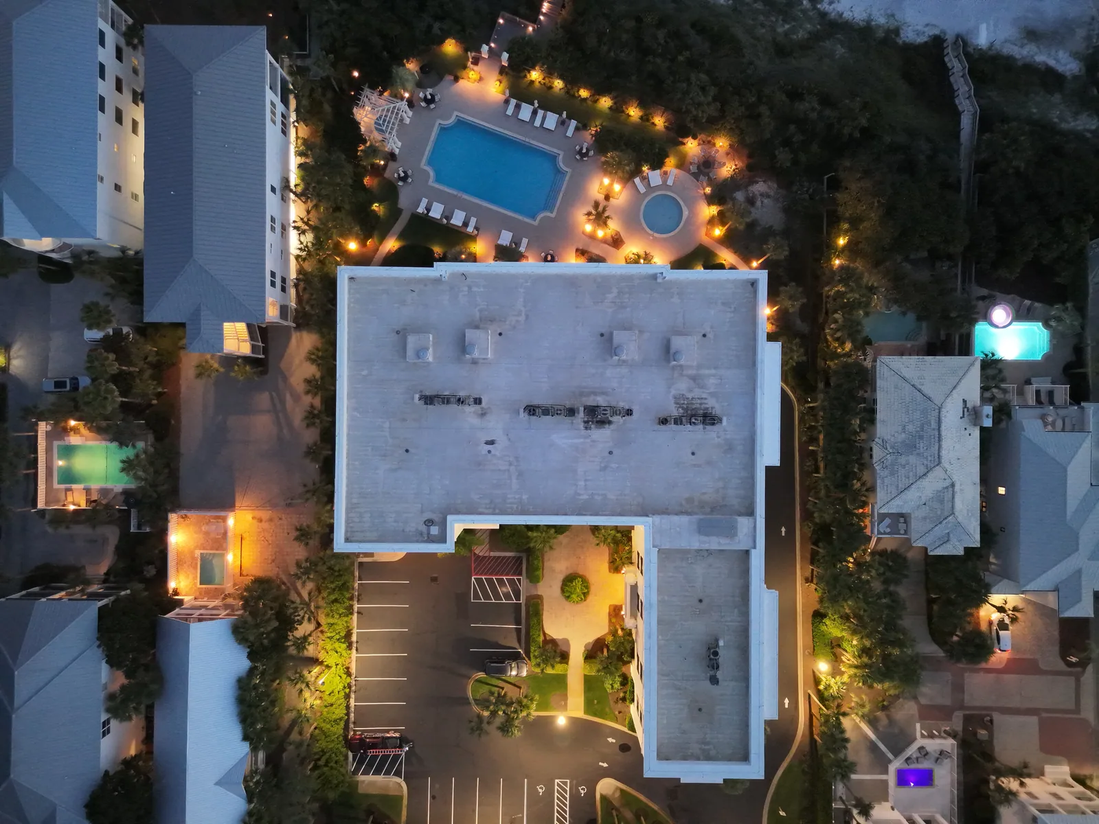Visible-light frame of a roof, pool and surrounding property at dusk