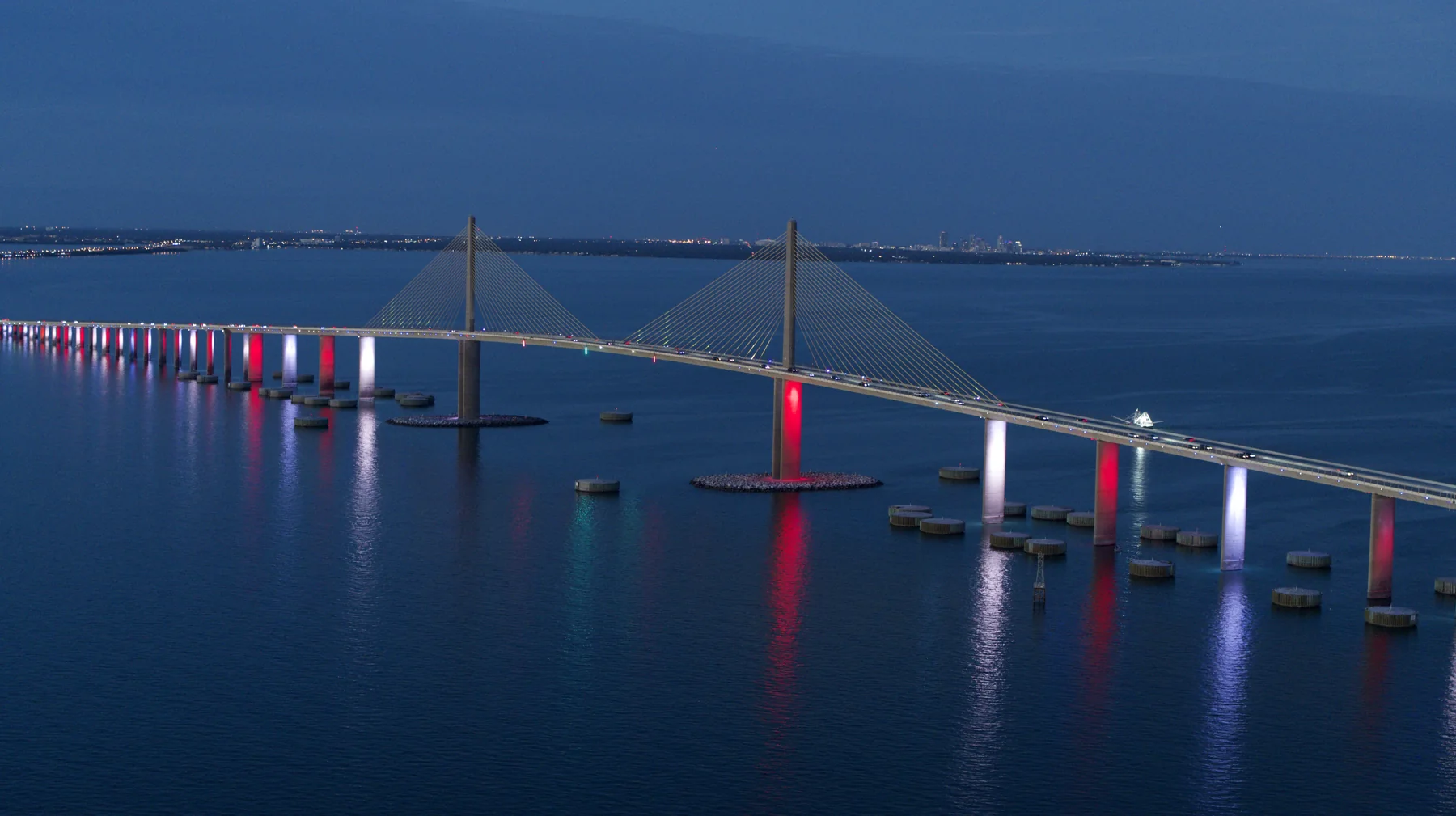 Dusk aerial photograph of a cable-stayed bridge over blue water