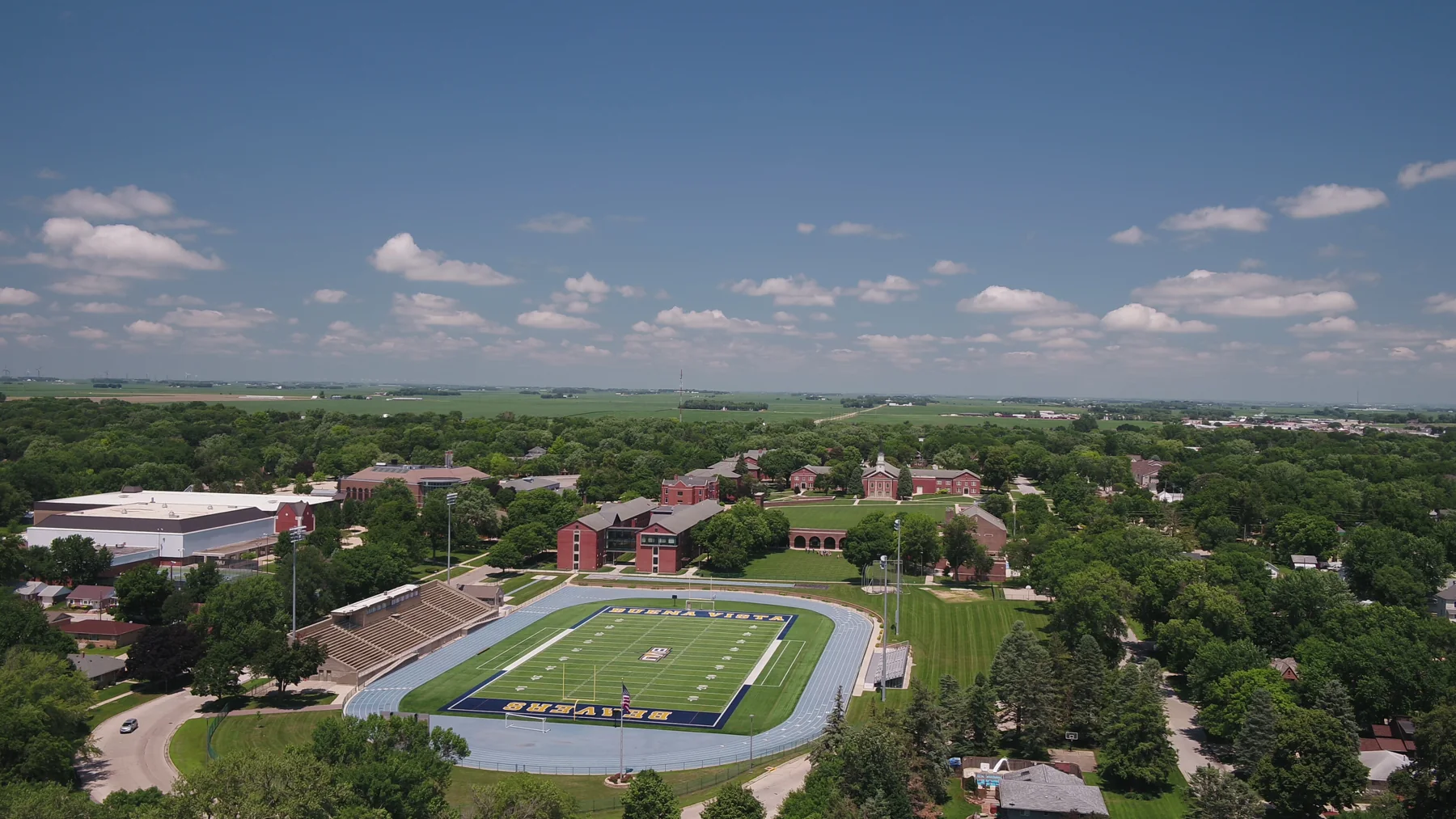 Aerial panorama of inland buildings, green grounds and surrounding trees