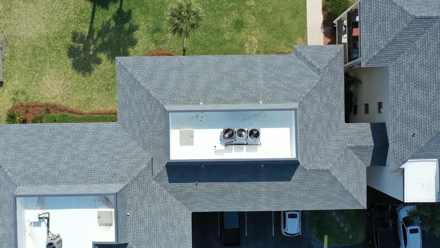 Top-down roof photograph showing shingles, roof edges and rooftop equipment